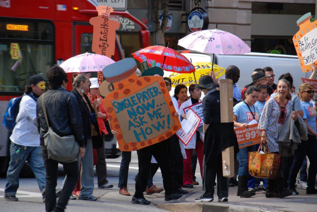 an image of a group of people protesting outdoors with lots of signs