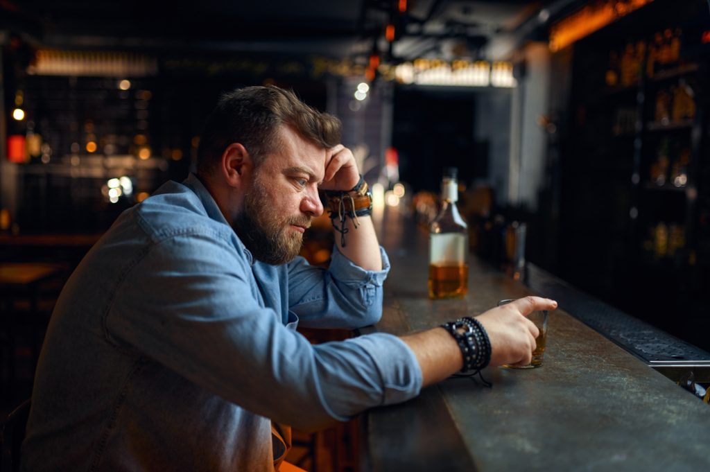 Sad bearded man sitting at the counter in bar | Heal CA