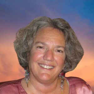 Jodi Reid smiling and wearing earrings and a satin shirt
