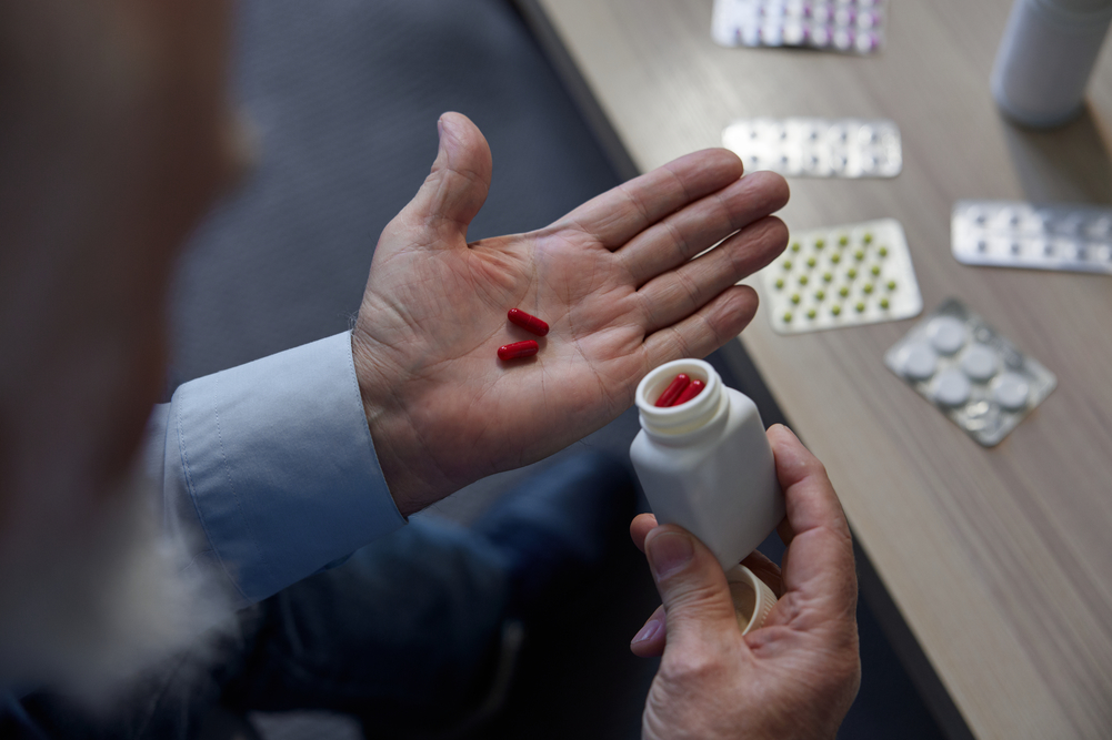 Medical pills tablets and capsules in senior man hand. Elderly healthcare, pharmaceuticals for treatment and health insurance